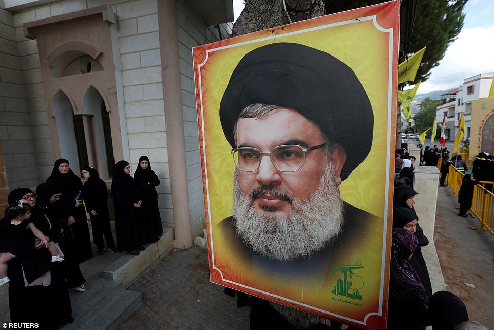 90208741-13901583-People_stand_near_a_picture_of_Hezbollah_leader_Sayyed_Hassan_Na-a-14_172752...jpg