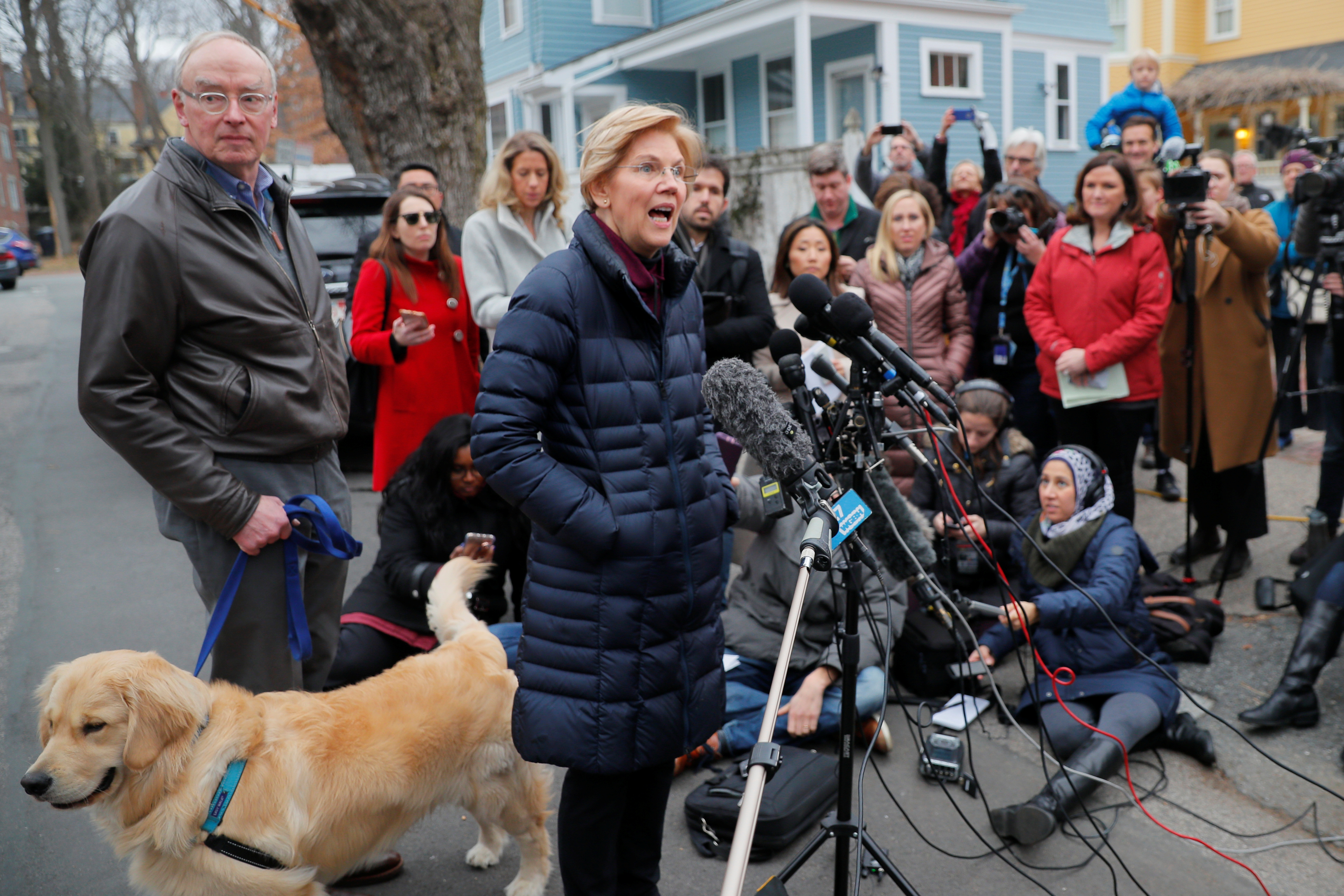 U.S. Senator Warren is joined by her husband Bruce and dog Bailey as she speaks to reporters in Cambridge