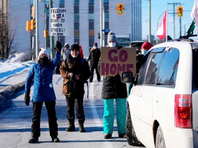 Residents participate in a counter protest to stop vehicles from driving in a convoy en route to Parliament Hill, on the 17th day of a protest against COVID-19 measures that has grown into a broader anti-government protest, in Ottawa, Sunday, Feb. 13, 2022.