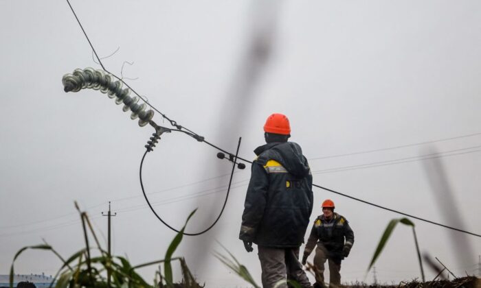 Workers repair high-voltage power lines cut by recent missile strikes near Odessa on Dec. 7, 2022, amid the Russian invasion of Ukraine.   (Photo by Oleksandr Gimanov/AFP via Getty Images)