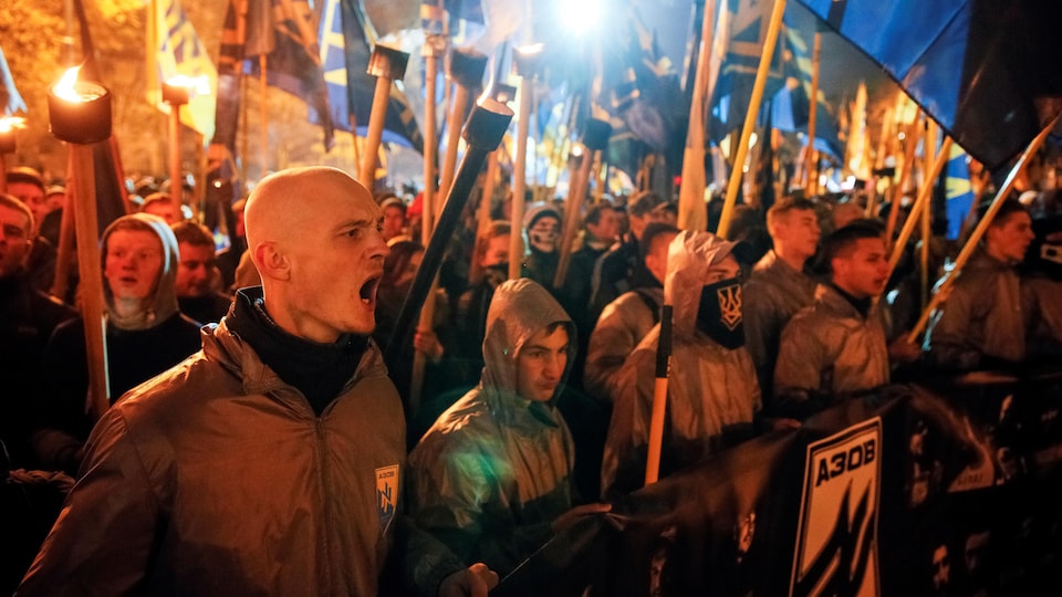 Une foule brandit des drapeaux et des flambeaux pour souligner ce jour.