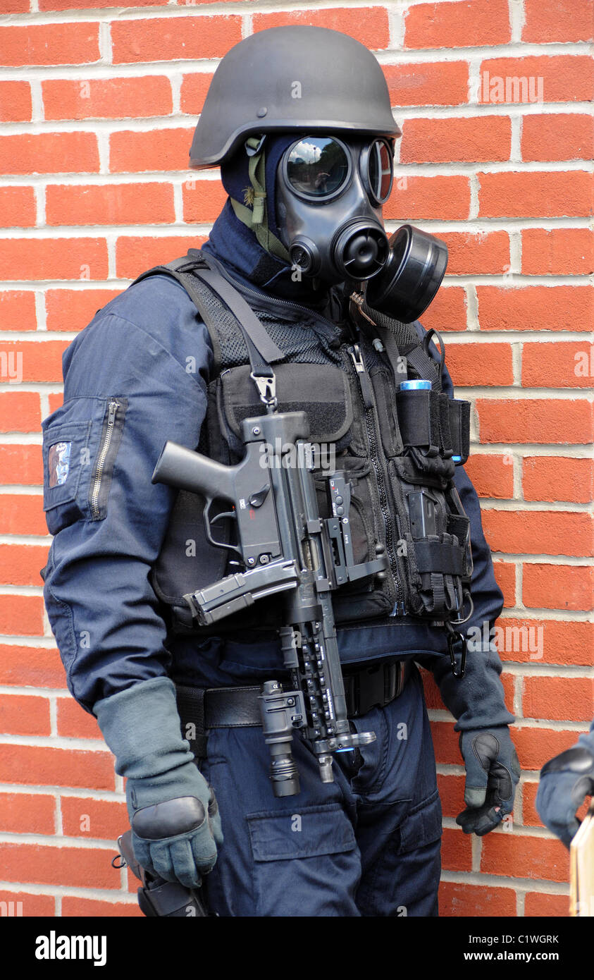 police-swat-officer-in-gas-mask-with-mp5-machine-gun-real-police-officer-C1WGRK.jpg