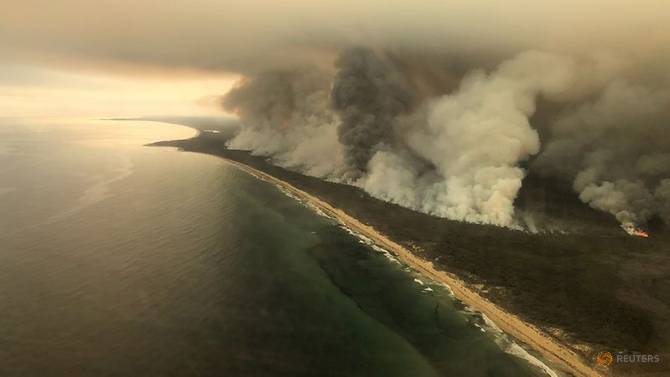 Thick plumes of smoke rise from bushfires at the coast of East Gippsland, Victoria