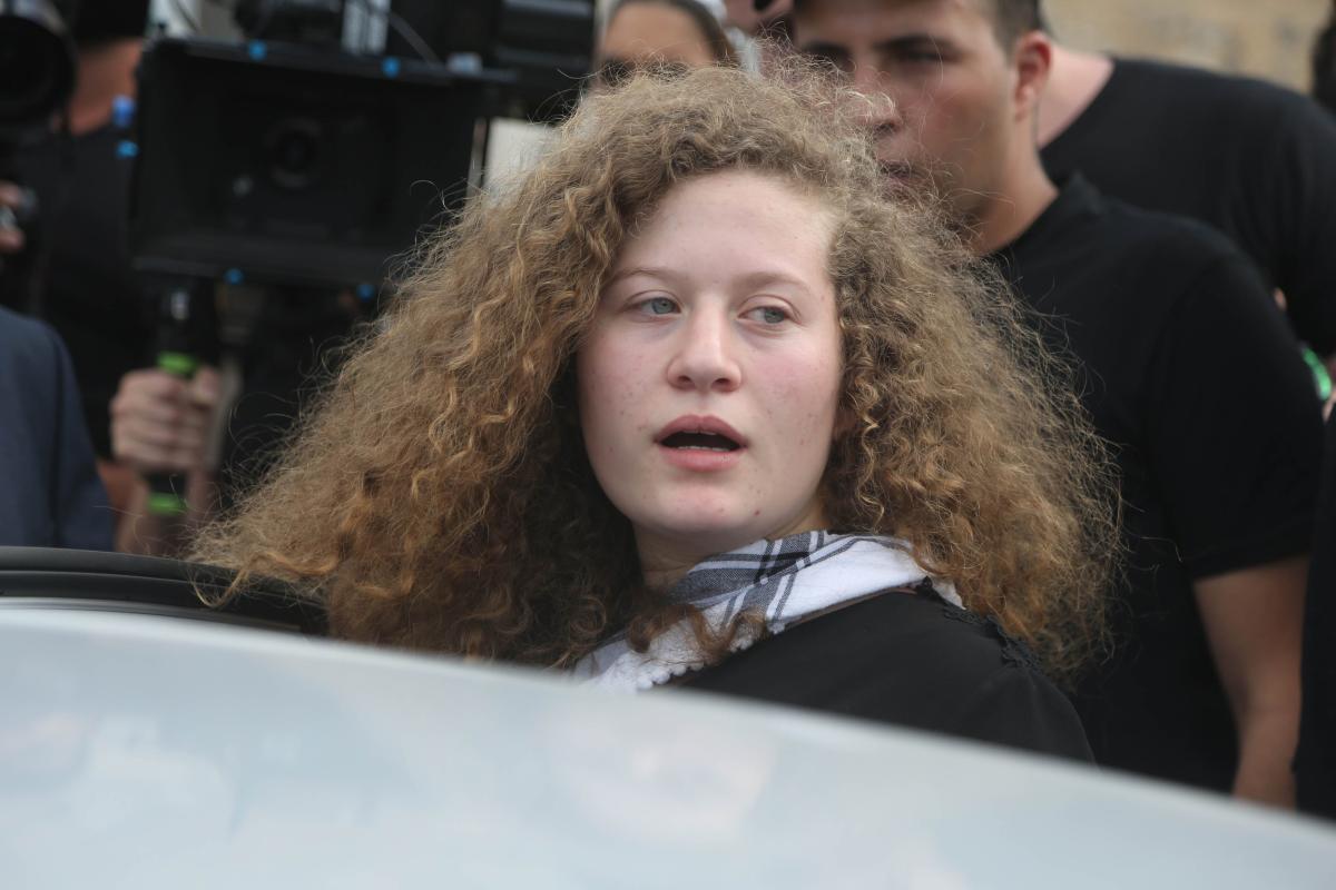 Palestinian teenager Ahed al-Tamimi (C) and her mother Nariman Tamimi (not seen) are welcomed by press members and citizens at the entrance of in Nabi Salih village of Ramallah, West Bank on 29 July, 2018 [Issam Rimawi/Anadolu Agency]