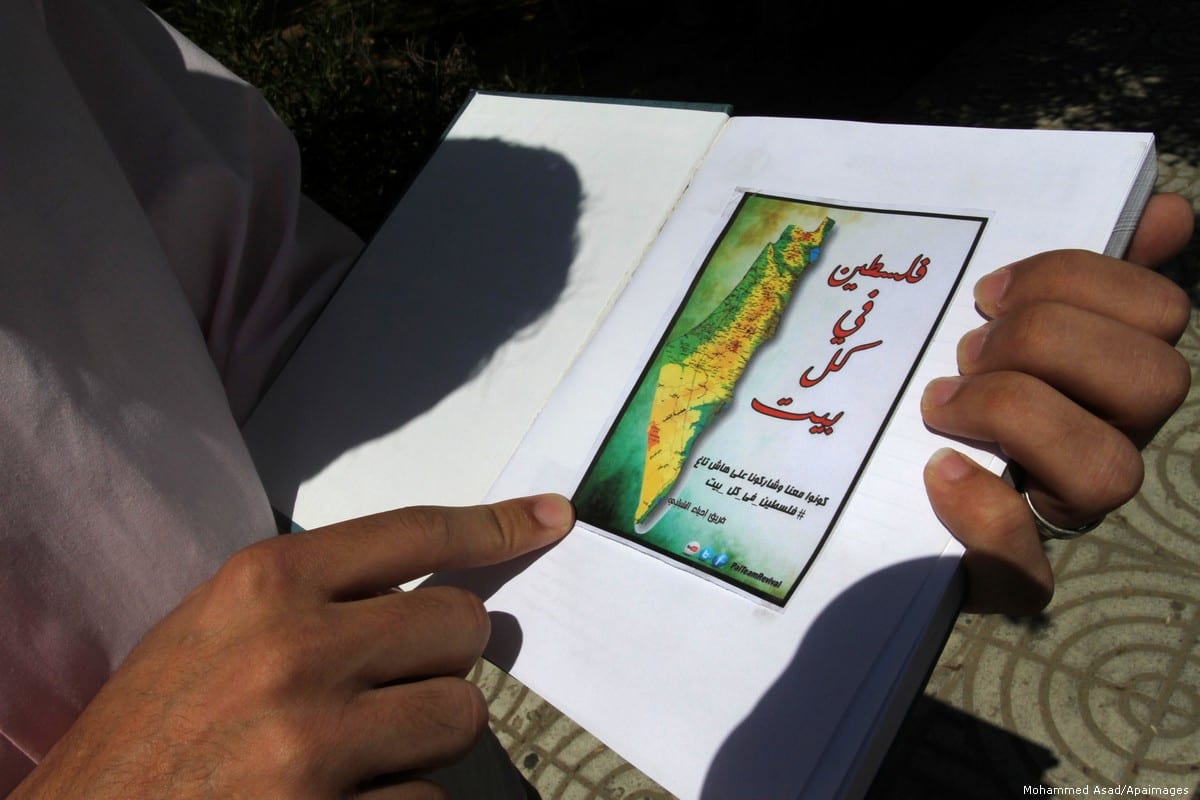 Palestinian man with a map of Palestine in Gaza city, 20 June 2013 [Mohammed Asad/Apaimages]