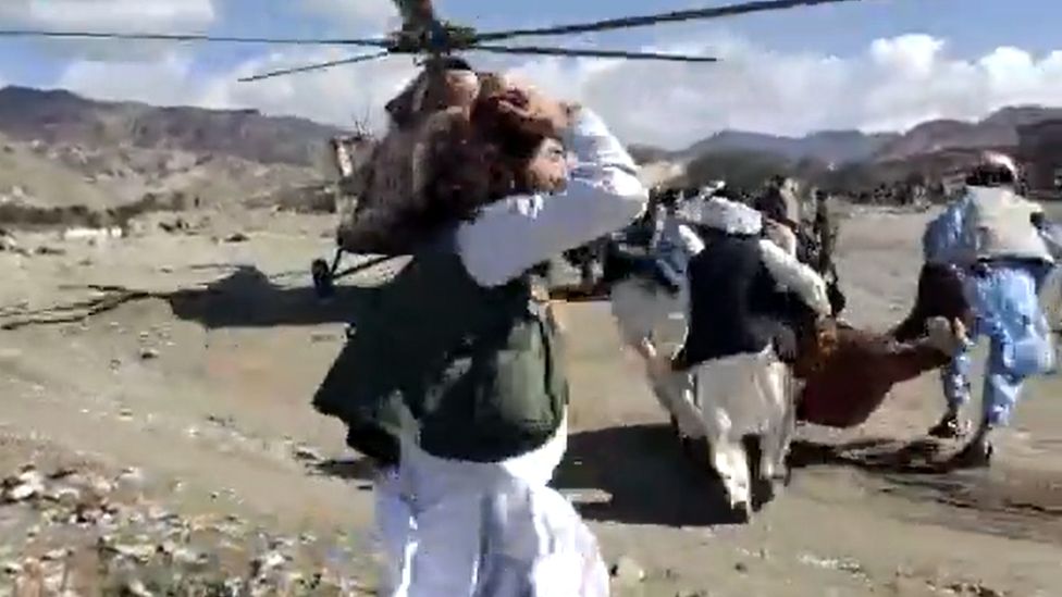 Rescuers carrying injured people to a helicopter in Paktika province