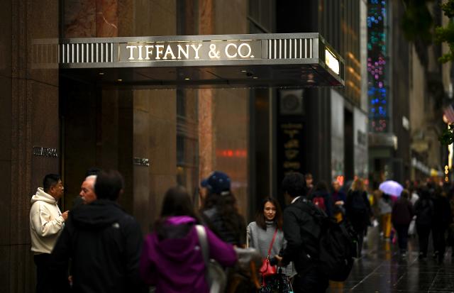 People walk past the headquarters of luxury jewelry and specialty retailer Tiffany & Co on 5th Avenue in Manhattan on October 27, 2019 in New York City. - LVMH, the French owner of Louis Vuitton, is exploring a takeover of Tiffany & Co to expand in the US jewelry market, according to reports. (Photo by Johannes EISELE / AFP) (Photo by JOHANNES EISELE/AFP via Getty Images)