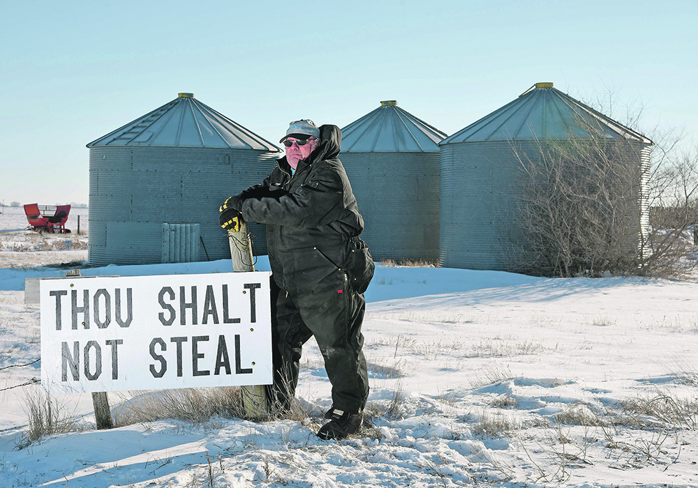 Miles Moore put this sign at the entrance to his farm near Outlook, Sask., after 1,800 bushels of canola — $40,000 worth — was stolen from one of his bins this January. Farmers are using technology from social media to security systems to detect and act upon suspicious behaviour. | William DeKay photo Miles Moore put this sign at the entrance to his farm near Outlook, Sask., after 1,800 bushels of canola — $40,000 worth — was stolen from one of his bins this January. Farmers are using technology from social media to security systems to detect and act upon suspicious behaviour. | William DeKay photo