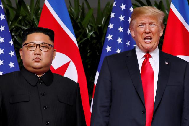 FILE PHOTO: U.S. President Donald Trump and North Korean leader Kim Jong Un react at the Capella Hotel on Sentosa island in Singapore June 12, 2018. REUTERS/Jonathan Ernst/File Photo