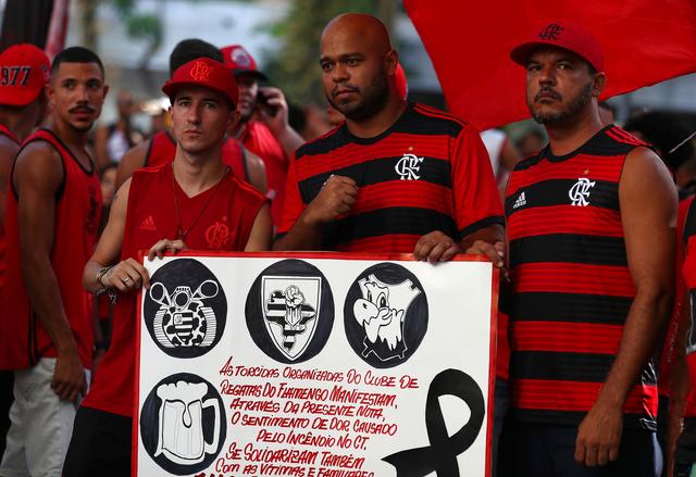 Soccer fans of Flamengo soccer club hold a banner in front of the club's headquarters after a deadly fire in their training center, in Rio de Janeiro, Brazil February 9, 2019. REUTERS/Pilar Olivares
