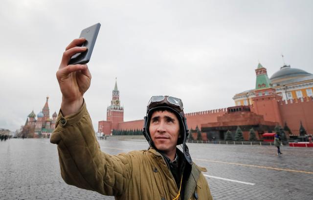 FILE PHOTO: A Russian Army member, dressed in a historical uniform, takes a selfie as he attends a rehearsal for a military parade to mark the anniversary of a historical parade in 1941, when Soviet soldiers marched towards the front lines at the Red Square in Moscow, Russia November 5, 2017.  REUTERS/Maxim Shemetov/File Photo