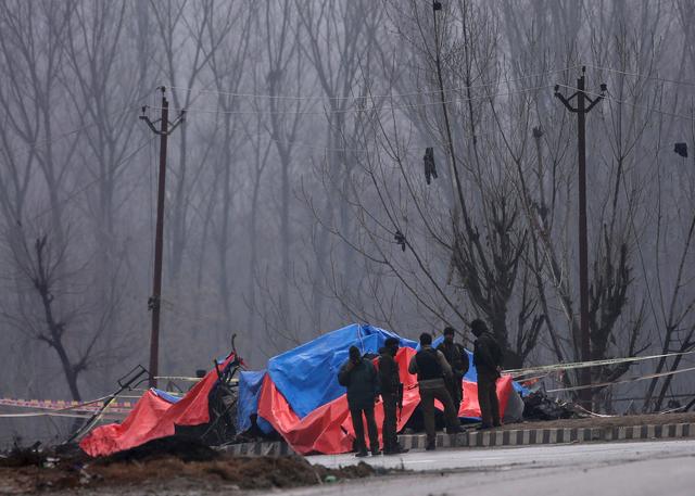 Forensic and security officials stand next to the wreckage of a bus after a suicide bomber rammed a car into the bus carrying Central Reserve Police Force (CRPF) personnel on Thursday, in Lethpora in south Kashmir's Pulwama district, February 15, 2019. REUTERS/Danish Ismail  