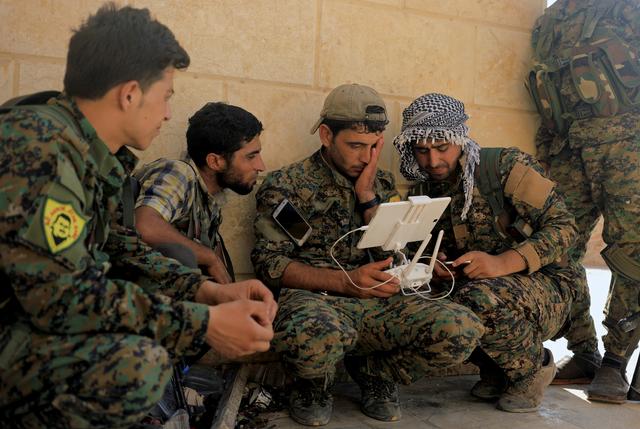 Members of the Syrian Democratic Forces control the monitor of their drone at their advanced position, during the fighting with Islamic State's fighters in Nazlat Shahada, a district of Raqqa, Syria August 16, 2017. REUTERS/Zohra Bensemra   