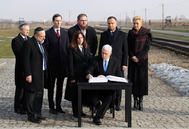 U.S. Vice President Mike Pence signs the visitors book at the Monument to the Victims at the former Nazi German concentration and extermination camp Auschwitz II-Birkenau, near Oswiecim, Poland, February 15, 2019. REUTERS/Kacper Pempel