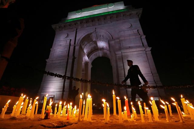 A soldier walks during a candle light vigil to pay tribute to Central Reserve Police Force (CRPF) personnel who were killed after a suicide bomber rammed a car into the bus carrying them in south Kashmir on Thursday, in front of India Gate war memorial in New Delhi, India, February 16, 2019. REUTERS/Anushree Fadnavis    