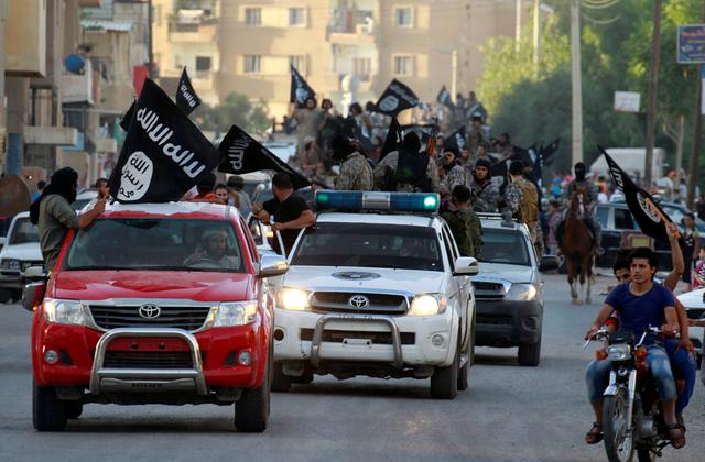 FILE PHOTO -  Militant Islamist fighters waving flags, travel in vehicles as they take part in a military parade along the streets of Syria's northern Raqqa province June 30, 2014.  REUTERS/Stringer/File Photo