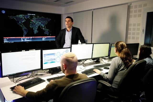 Lavy Shtokhamer, director of Israel's Computer Emergency Response Centre (CERT) stands in front of screens displaying a world map and other data as employees work at a cyber hotline facility in Beersheba, southern Israel February 14, 2019.  REUTERS/Amir Cohen