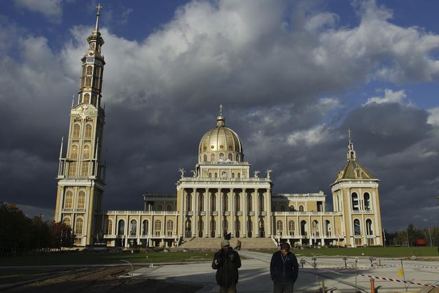 FILE PHOTO: Workers walk in front of Poland’s largest Roman Catholic church and one of the largest in the world, Basilica of Our Lady of Lichen, in Lichen Stary, near Konin, central Poland October 9, 2012. REUTERS/Kacper Pempel
