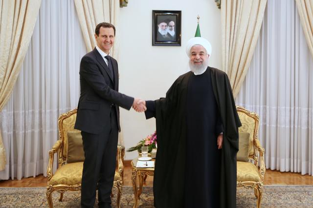 Iranian President Hassan Rouhani shakes hands with Syrian President Bashar al Assad, in Tehran, Iran, February 25, 2019. Official President website/Handout via REUTERS 