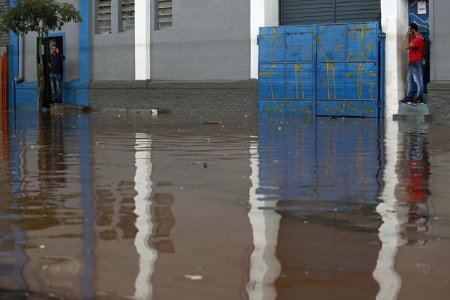 Men wait for the water level to drop in a flooded street after heavy rains in Vila Prudente neighbourhood in Sao Paulo, Brazil March 11, 2019. REUTERS/Amanda Perobelli 