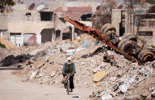 A man rides on a bike past rubble in Ein Terma, a district of eastern Ghouta, Syria February 26, 2019.  Picture taken February 26, 2019. REUTERS/Omar Sanadiki