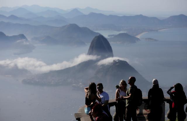 FILE PHOTO: Tourists are seen with the Sugarloaf Mountain in the background in Rio de Janeiro, Brazil June 21, 2018. REUTERS/Bruno Kelly/File Photo