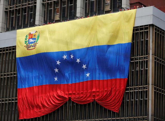 FILE PHOTO: A Venezuelan flag hangs from a building in Caracas March 11, 2013. REUTERS/Tomas Bravo/File Photo