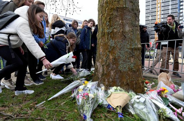 Children place flowers at the site of a shooting in Utrecht, the Netherlands March 19, 2019. REUTERS/Piroschka van de Wouw
