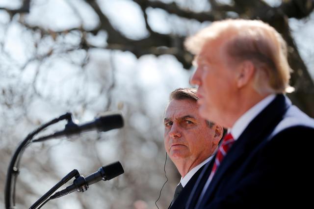 FILE PHOTO: Brazilian President Jair Bolsonaro listens to U.S. President Donald Trump during a joint news conference in the Rose Garden of the White House in Washington, U.S., March 19, 2019. REUTERS/Carlos Barria/File Photo