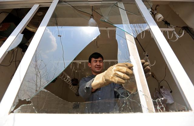 A man removes broken glass from a window after multiple explosions in Kabul, Afghanistan, March 21, 2019. REUTERS/Parwiz