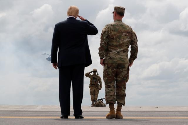 FILE PHOTO: U.S. President Donald Trump salutes a U.S. Army soldier as he observes a military demonstration with U.S. Army Major General Walter “Walt” Piatt, the Commanding General of the Army's 10th Mountain Division at Fort Drum, New York, U.S., August 13, 2018. REUTERS/Carlos Barria