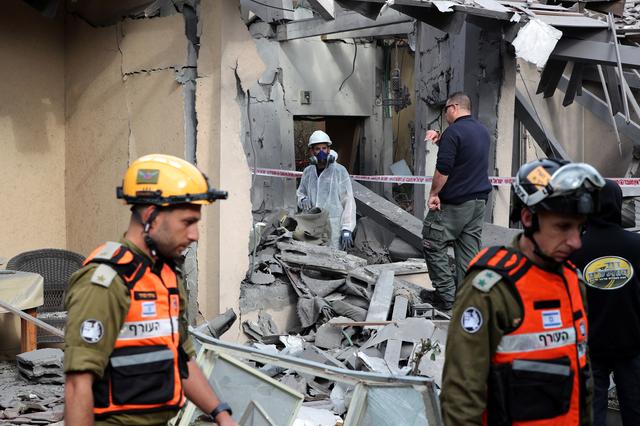 Israeli policemen and soldiers inspect a damaged house that was hit by a rocket north of Tel Aviv Israel March 25, 2019. REUTERS/ Ammar Awad