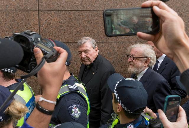 FILE PHOTO - Vatican Treasurer Cardinal George Pell is surrounded by Australian police and members of the media as he leaves the Melbourne Magistrates Court in Australia, July 26, 2017.    REUTERS/Mark Dadswell/File Photo