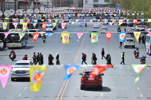 People cross a road under flags marking Tibetan Serfs' Emancipation Day on March 28, in Lhasa, Tibet Autonomous Region, China March 26, 2019. Picture taken March 26, 2019. REUTERS/Stringer 