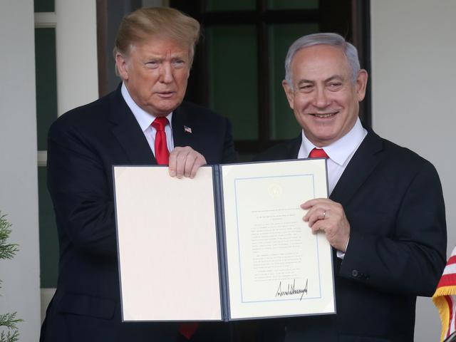 FILE PHOTO: U.S. President Donald Trump and Israel's Prime Minister Benjamin Netanyahu hold up a proclamation recognizing Israel's sovereignty over the Golan Heights as Netanyahu exits the White House from the West Wing in Washington, U.S. March 25, 2019. REUTERS/Leah Millis/File Photo