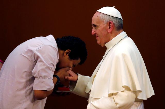 FILE PHOTO: A youth kisses the ring of Pope Francis during a meeting at the municipal theater in Rio de Janeiro, July 27, 2013. REUTERS/Stefano Rellandini/File Photo