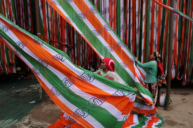 FILE PHOTO: A worker pulls a roll of flags of India's main opposition Congress party kept for drying at a flag manufacturing factory, ahead of the 2019 general elections, in Ahmedabad, India, March 13, 2019. REUTERS/Amit Dave/File Photo