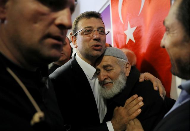 FILE PHOTO: Ekrem Imamoglu, main opposition Republican People's Party (CHP) candidate for mayor of Istanbul, embraces his supporter at his election campaign office in Istanbul, Turkey April 1, 2019. REUTERS/Huseyin Aldemir/File Photo
