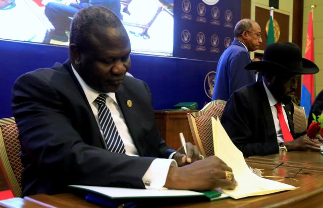 FILE PHOTO: South Sudanese rebel leader Riek Machar (L) and South Sudan's President Salva Kiir sign a cease fire and power sharing agreement in Khartoum, Sudan August 5, 2018. REUTERS/Mohamed Nureldin Abdallah/File Photo