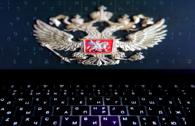 FILE PHOTO: The coat of arms of Russia is reflected in a laptop screen in this picture illustration taken February 12, 2019. REUTERS/Maxim Shemetov/File Photo