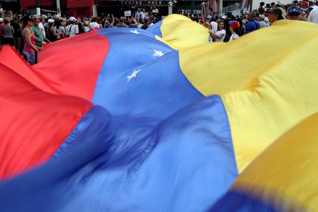 People display a huge Venezuelan flag as they take part in a protest against Venezuelan President Nicolas Maduro's government in Caracas, Venezuela, April 10, 2019. REUTERS/Ivan Alvarado