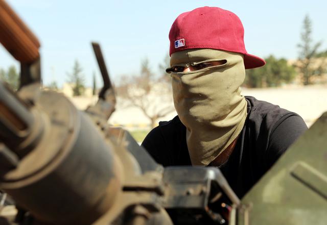A masked member of Libyan internationally recognised pro-government forces is seen in a military vehicle on the outskirts of Tripoli, Libya April 10, 2019. REUTERS/Hani Amara