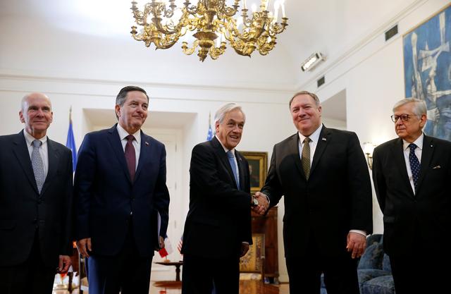 U.S. Secretary of State Mike Pompeo shakes hands with Chile's President Sebastian Pinera as he stands near Chile's Foreign Minister Roberto Ampuero at the presidential palace La Moneda, in Santiago, Chile April 12, 2019. REUTERS/Rodrigo Garrido