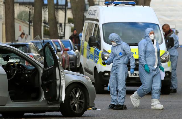Police forensics officers work at the site where police fired shots after a vehicle rammed the parked car of Ukraine's ambassador, outside the Ukrainian embassy in London, Britain, April 13, 2019. REUTERS/Gonzalo Fuentes