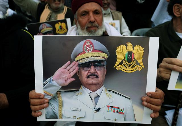 FILE PHOTO: A Libyan man carries a picture of Khalifa Haftar during a demonstration to support Libyan National Army offensive against Tripoli, in Benghazi, Libya April 12, 2019. REUTERS/Esam Omran Al-Fetori