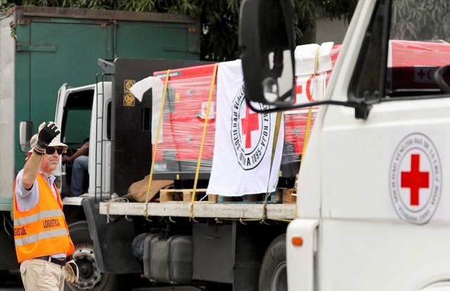A worker directs trucks with logo of the International Federation of Red Cross and Red Crescent Societies (IFRC) carrying humanitarian aid, at a warehouse where the aid will be stored, in Caracas, Venezuela, April 16, 2019. REUTERS/Manaure Quintero 