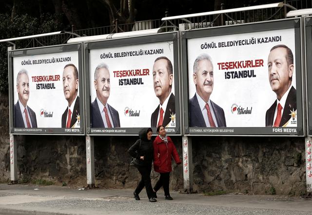 FILE PHOTO - People walk past by AK Party billboards with pictures of Turkish President Tayyip Erdogan and mayoral candidate Binali Yildirim in Istanbul, Turkey, April 1, 2019. The billboards read:  Thank you Istanbul .  REUTERS/Murad Sezer