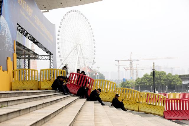 Security officers rest on steps at an exhibition to mark China's Space Day 2019 on April 24, in Changsha, Hunan province, China, April 23, 2019. REUTERS/Aly Song
