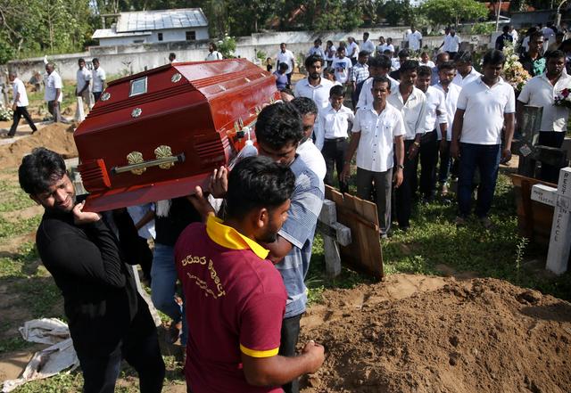 A coffin of a victim is carried during a mass burial of victims, two days after a string of suicide bomb attacks on churches and luxury hotels across the island on Easter Sunday, at a cemetery near St. Sebastian Church in Negombo, Sri Lanka April 23, 2019. REUTERS/Athit Perawongmetha