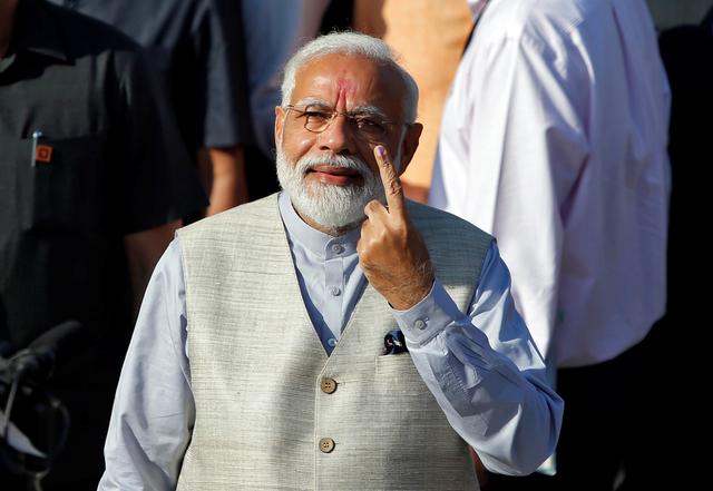 India's Prime Minister Narendra Modi shows his ink-marked finger after casting his vote outside a polling station during the third phase of general election in Ahmedabad, India, April 23, 2019. REUTERS/Amit Dave